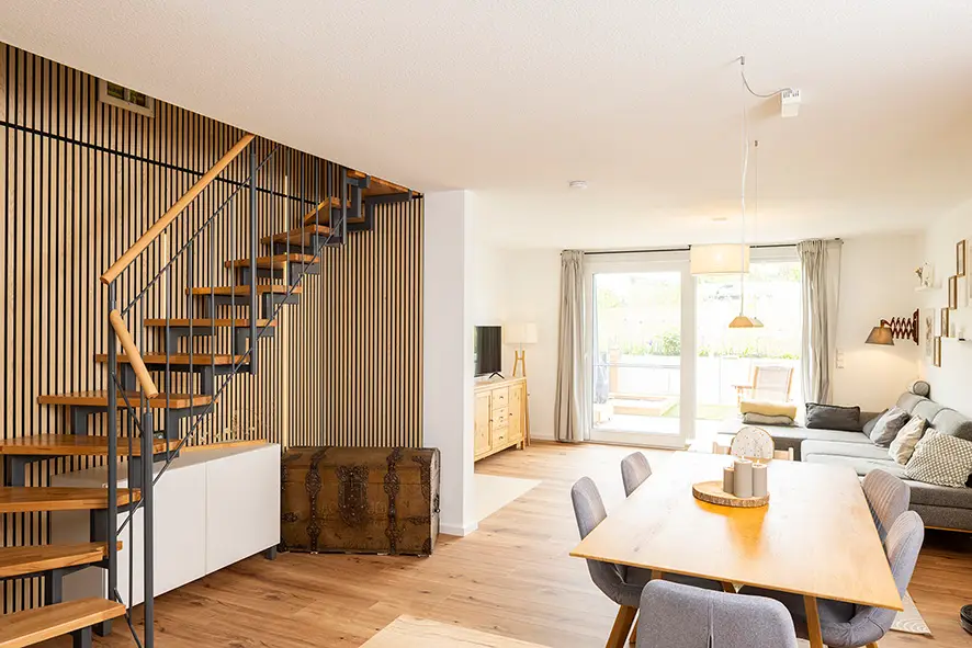 Dining and living area with dining table, sofa and TV, open to the kitchen
