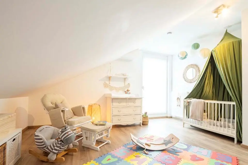 Children’s room in the attic with a baby cot and rocking chair