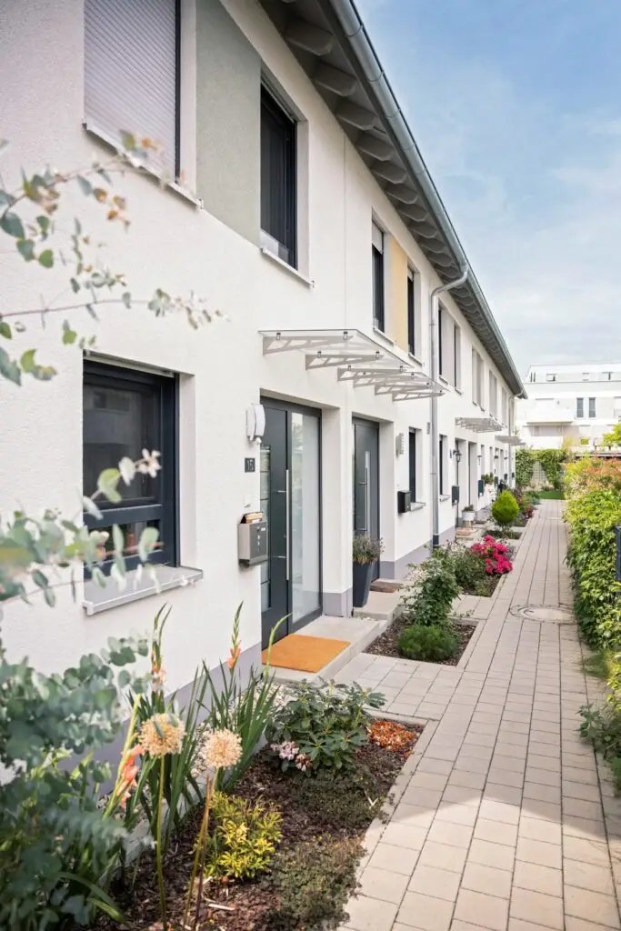 Row of houses with flowers and plants along the sidewalk