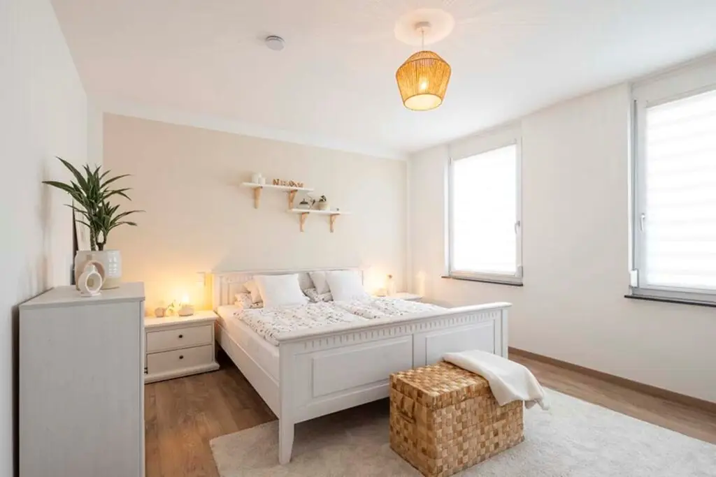 Bedroom on the upper floor with a white bed and dresser